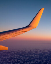 Plane Wing Over Clouds At Sunset