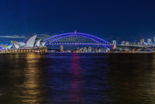 Colourful Light Show At Night On Sydney Harbour NSW Australia. The Bridge Illuminated With Lasers And Neon Coloured Lights. Sydney Laser Light Show