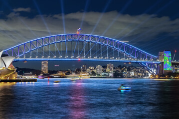 Wall Mural - Colourful Light show at night on Sydney Harbour NSW Australia. The bridge illuminated with lasers and neon coloured lights. Sydney laser light show