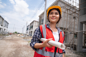 Mechanical engineer Asia woman with paper work on construction home building site	