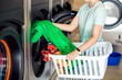 © Aleksej - Public laundry. Inserting dirty clothes into the washing machine in the laundry room