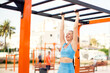 © Aleksej - Fitness girl doing exercises on the horizontal bar on street sport gym