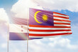 Sunny blue sky and flags of malaysia and honduras