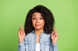 © Tetiana - Photo of young girl crossed fingers wish hope luck success anxious isolated over green color background