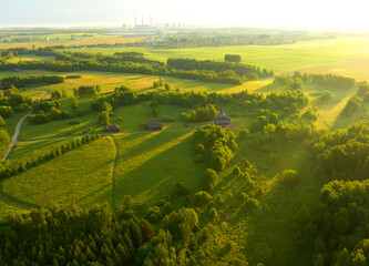 Village with wooden houses near forest. Field and forest in wild on sunrise. Country house in rural. Green fields and farmland. Village aerial view. Suburban house in rural. Old rural house in village