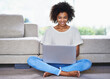 © Mapodile M./peopleimages.com - Staying connected is just so easy nowadays. Shot of a young woman using a laptop while relaxing at home.