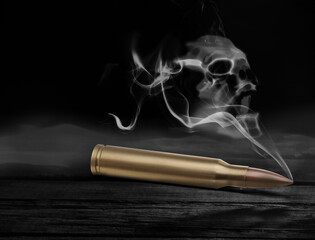 Wall Mural - Bullet with skull shaped smoke on black wooden table