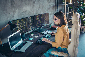 profile side view portrait of attractive focused skilled girl web developer using laptop at workplac