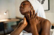 © ADDICTIVE STOCK - Black woman applying cream on neck