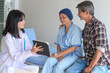 © tonefotografia - Cancer patient woman wearing head scarf after chemotherapy consulting and visiting doctor in hospital....