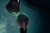 brush makeup tool, make-up brush with powder explosion isolated on black