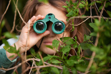 Poster - Bird watching is serious. Shot of a cute little girl looking through a pair of binoculars outdoors.