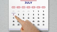Close-up Of A Male Hand Pointing Finger To Independence Day Date On July Page Of The Wall Calendar 2022