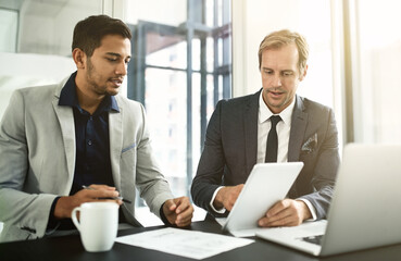 Sticker - Technology allows them to reach new economic markets. Shot of two businesspeople having a discussion in an office.