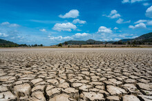 Landscape Photography Of The Cracks In The Bottom Of A Dry Lake In The Background Of A House And The Blue Sky At Noon