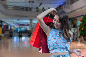 Young woman holding shopping bags in the shopping mall.