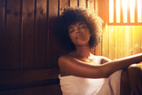 Her place of peace.... A young woman relaxing in the sauna at a spa.