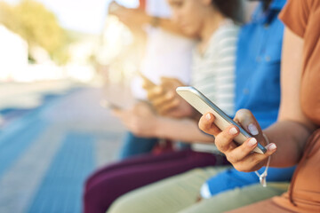 Poster - Lets see if we have any messages. Shot of a group unrecognizable people using their phones outside during the day.