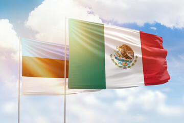 Sunny blue sky and flags of mexico and estonia