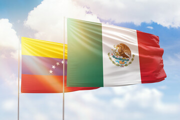 Sunny blue sky and flags of mexico and venezuela