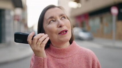 Sticker - Middle age woman smiling confident talking on the smartphone at street