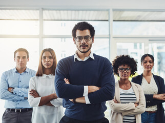 Poster - The are very confident in their field of work. Portrait of a group of confident young businesspeople standing with their arms folded inside of the office together.