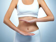 © Nikish Hiraman/peopleimages.com - Happiness is a healthy body. Shot of an unidentifiable young woman posing with her hands over her stomach in the studio.
