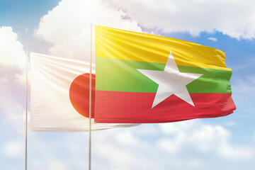 Sunny blue sky and flags of myanmar and japan