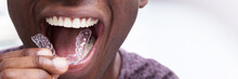Man Adjusting Transparent Aligners In His Teeth