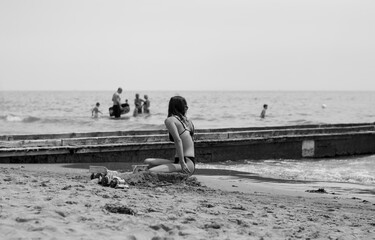 Canvas Print - the woman Watch the baby enter the water among the waves