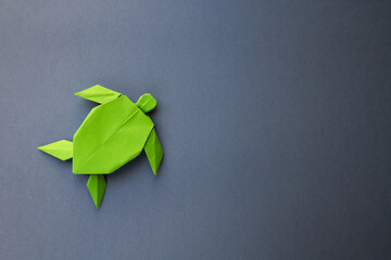 Wall Mural - green paper turtle origami isolated on a grey background