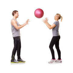 Wall Mural - Getting fit together. A man and woman exercising by throwing a medicine ball to each other.