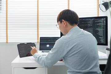 Wall Mural - software development concept, male programmer point data on tablet to checking website programming