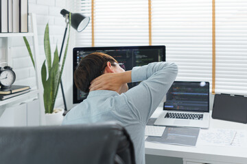 Wall Mural - software development concept, male programmer suffering neck pain after working hard on computer