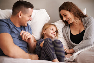 Poster - In bed with mom and dad. Cropped shot of an affectionate young family lying in bed together.