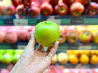 hand holding green apple Blur apple background 