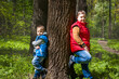 © Alina Lebed - Two brothers in the forest in the spring. Interaction of children. Take a walk in the green park in the fresh air. The magical light from the sun's rays falls behind.