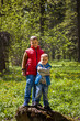 © Alina Lebed - Two brothers in the forest in the spring. Interaction of children. Take a walk in the green park in the fresh air. The magical light from the sun's rays falls behind.