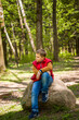 © Alina Lebed - Portrait of a young man in a red tank top in the forest in spring. Walk through the green park in the fresh air. The magical light from the sun's rays falls behind the boy.