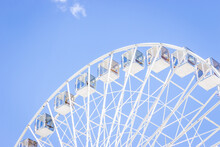 Ferris Wheel On A Blue Sky. Amusement Park. Empty Ferris Wheel On Sunny Day In Kyiv, Ukraine. Summer Recreation. Leisure Activity. Big Circle Vintage Carousel On Blue Sky. Outdoors Attraction.