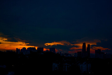 Wall Mural - sunset with dark rainy clouds over modern city