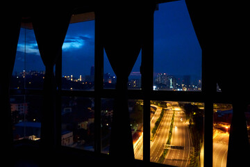 Wall Mural - Night view from the window of the apartment on a multi-lane highway in the direction of the metropolis. Night view.