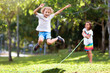 Happy kids play outdoor. Children skipping rope.