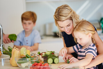 Canvas Print - Shes a great little chef. Cropped shot of a mother cooking together with her two kids at home.