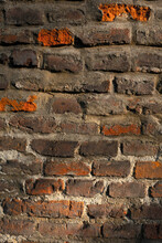 Demaged Rough Brick Wall Surface. Old Brown And Red Brick Wall In The Light Of The Setting Sun. Cool Background. Medieval Wall.