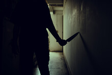 The Shadow Of A Female Murderer Stood Terrifyingly Holding A Knife And Lit From Behind.Scary Horror Or Thriller Movie Mood Or Nightmare At Night Murder Or Homicide Concept.