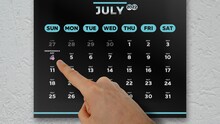 Close-up Of A Male Hand Pointing Finger To Independence Day Date On July Black Page Of The Wall Calendar 2022