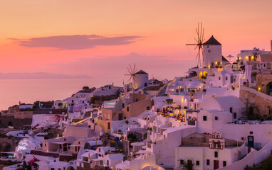  Oia village, Santorini, Greece. View of traditional houses in Santorini. Small narrow streets and rooftops of houses, churches and hotels. Landscape during sunset. Travel and vacation photography.