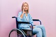 Beautiful blonde woman sitting on wheelchair touching mouth with hand with painful expression because of toothache or dental illness on teeth. dentist
