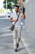 © Anne/peopleimages.com - Enjoying his favorite playlist. A handsome african american businessman walking through the city while listening to some music.